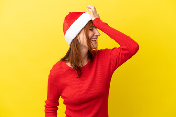 Redhead girl with christmas hat isolated on yellow background has realized something and intending the solution