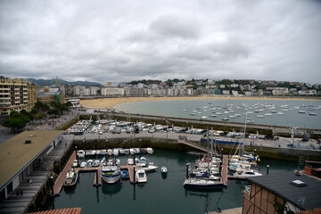 Obraz premium Puerto deportivo de San Sebastian, Pais vaso en un dia nublado con la playa de la concha al fondo. 