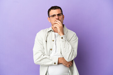 Brazilian man over isolated purple background surprised and shocked while looking right