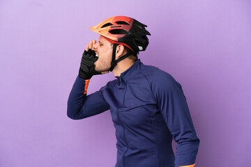 Young Brazilian cyclist man isolated on purple background shouting with mouth wide open to the side - obrazy, fototapety, plakaty