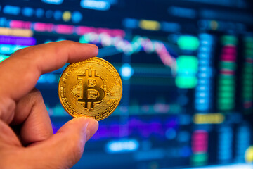 Moneda de Bitcoin con grafica en un monitor - obrazy, fototapety, plakaty
