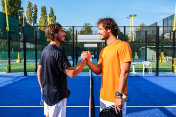 Portrait of handshake of two padel tennis players - Padel players embracing after win a padel match