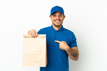 Brazilian taking a bag of takeaway food isolated on white background with surprise facial expression