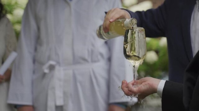 Jewish Wedding, hupa. Wine, the rabbi pours wine into a glass in full. Close-up