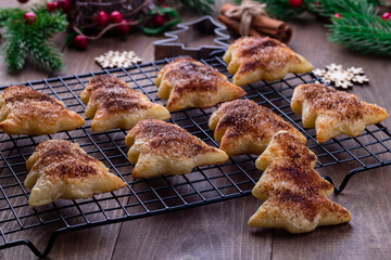 Christmas tree shaped puff pastry cookies with sugar and cinnamon on a cooling rack, horizontal