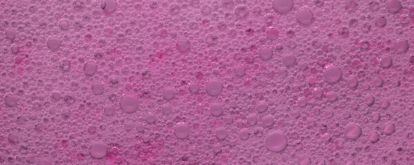 Pink abstract background, tiny air bubbles suspended in a thick pink liquid. Flat lay top view