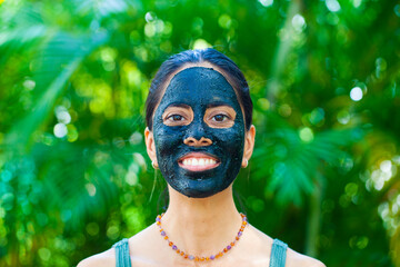 Happy woman with charcoal facemask  - 462972693