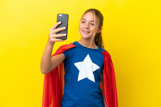 Super Hero little girl isolated on yellow background making a selfie