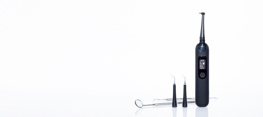Home-use dental tools. Electric teeth cleaner with led screen on white background with reflection