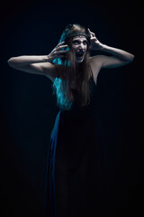 A young witch in agony, shouting and breaking into pieces, halloween horror