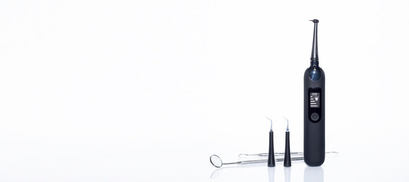 Home-use dental tools. Electric teeth cleaner with led screen on white background with reflection