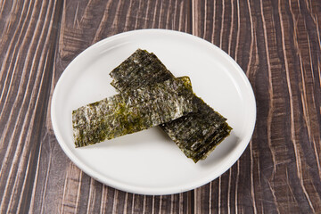 Crispy nori dried seaweed on wood background