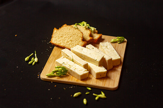 Composici&oacute;n de queso con loroco y pan en una tabla