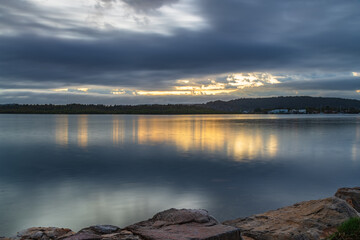 Sunrise waterscape with cloud covered sky