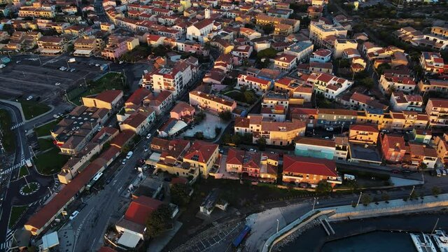 drone flying over the old town of Palau. Charming small city on the coast. romatic warm light from sunrise.