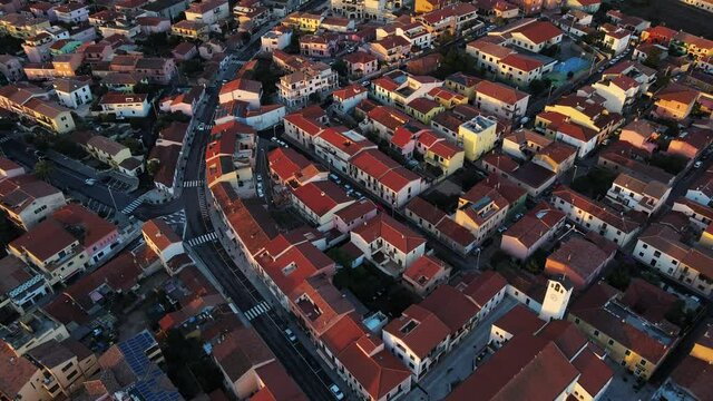 drone flying over the old town of Palau. Charming small city on the coast. romatic warm light from sunrise.