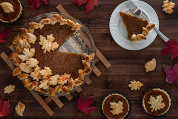Top down view of a homemade pumpkin pie with one slice removed.