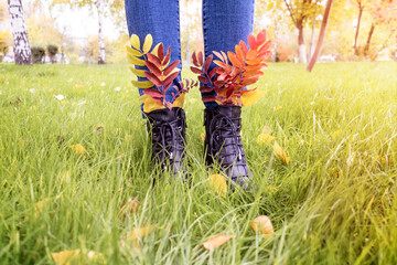 Autumn leaves tucked into boots for a walk in the park.deporsonalization. On an autumn walk
