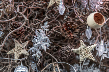 Close-up of Decorating Christmas tree background. Twigs christmas tree, brown natural pine cones, Disco ball, Star and edison light bulb, Selective focus.
