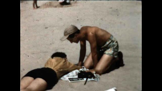 Beach Kiss 1950 - A young husband kisses his wife on the beach. 
