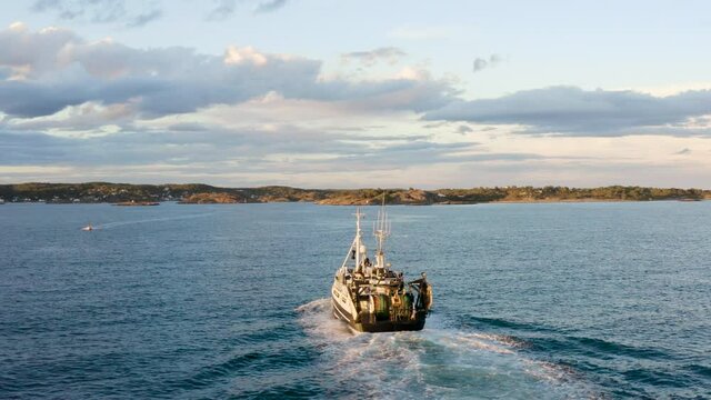 Aerial View Of Commercial Fishing Boat Going Home After Catching Fish In The Ocean In Norway. - rear