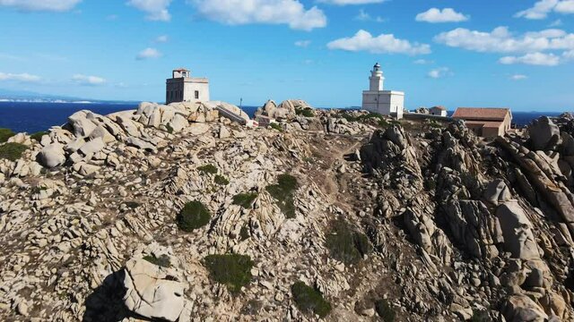 centuries old lighthouse and observation post. unique rocky coast, Capo Testa island, sardinia. bay was formed by the water of the mediterranean sea and the wind. Drone, aerial flying between.