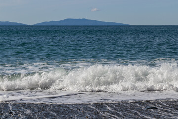 Waves on the beach with mountains on the horizon at Sombrio Beach on Vancouver Island