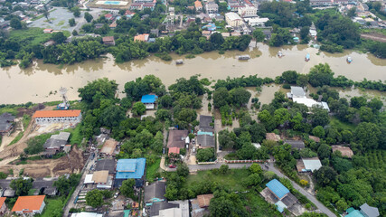 Fototapeta na wymiar Flood waters overtake a house and rice field at Central of Thailand in 2021. Many buildings are submerged in water. Photo disaster from above view by drone