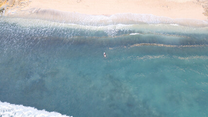 Surf drone aerial view surfer surfboard water sea ocean blue colors late afternoon summer visual environment landscape tropical place for vacation sport Asia Indonesia Bali beach