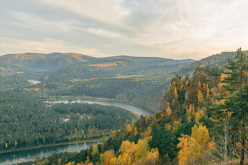Naklejka premium River valley on the background of beautiful mountains in autumn. Bird`s-eye view.