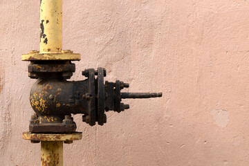 Old shut-off valves for pipelines on a concrete wall..Cast iron gate valve.Household gas pipeline.