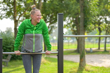 Happy healthy sporty middle-aged woman working out outdoors