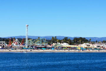 Scenic view of Santa Cruz Beach Boardwalk Amusement Park on sunny day under clear blue sky from Monterey Bay - obrazy, fototapety, plakaty