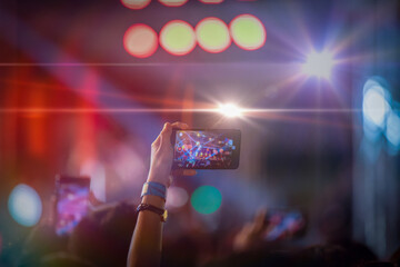 people holding smartphone in hands for shooting the concert stage
