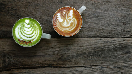 A cup of green tea matcha latte and cup of latte art coffee on wooden background                                                              