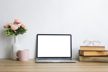 Mock up computer with books and coffee mug and roses over the light background. 