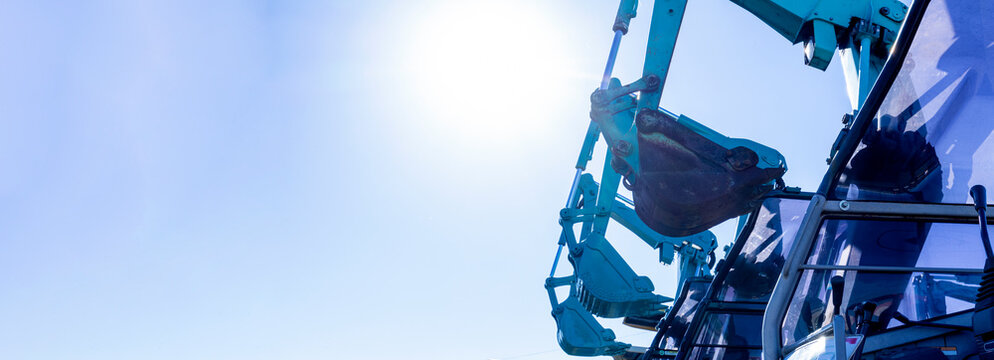 Images of lined up backhoe and blue sky