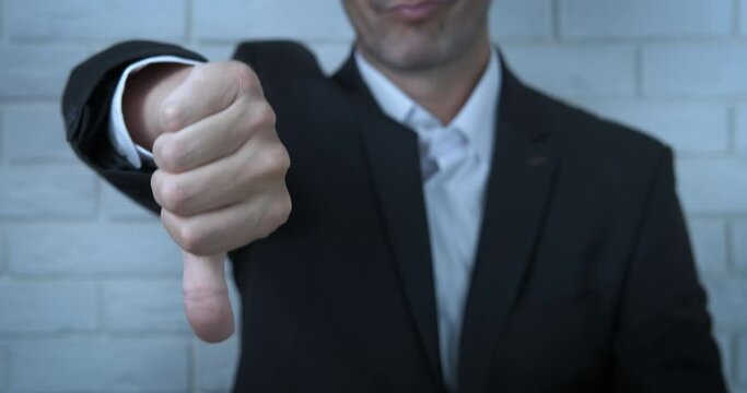 Choice thumb down. A man show that something in bad and drop down his thumb.