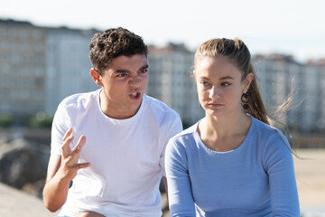Angry teenager boy shouting to her sad girlfriend. Toxic relationship concept.
