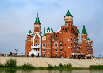 Fototapeta na wymiar View of the embankment with a building like a castle in historical style in Yoshkar-Ola, Russia