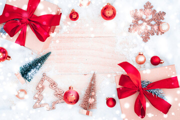 Table wood Christmas. Xmas board with old rustic wall, white frozen snow, golden balls and gift box. Winter wooden decoration background. Happy new year copy space.