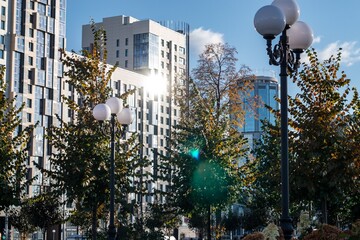 Cityscape view of tall buildings and a park with alleys and lanterns, Russia city of Yekaterinburg