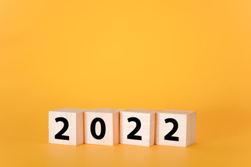 Wooden cubes on a yellow background and 2022.