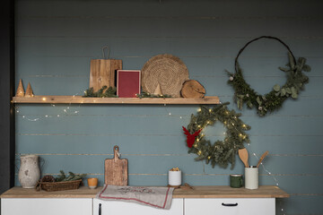 Minimalist home interior with cozy kitchen furniture, kitchenware, Christmas wreath on dusty blue...