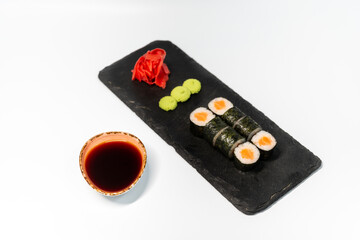 Hosomaki with salmon sushi on a blackboard on a white background