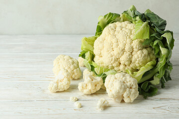 Fresh juicy cauliflower with slices on wooden background