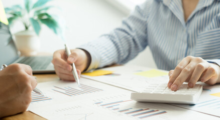Two business leaders talk about charts, financial graphs showing results are analyzing and calculating planning strategies, business success building processes