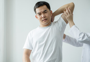 Female physiotherapists provide assistance to male patients with elbow injuries examine patients in rehabilitation centers. Physiotherapy concepts