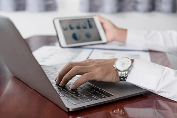 The businessman hand sits at their desks and calculates financial graphs showing the results of their investments planning the process of successful business growth