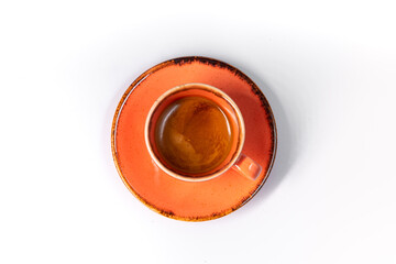 espresso in an orange cup on an orange plate on a white background, coffee cup top view isolated
